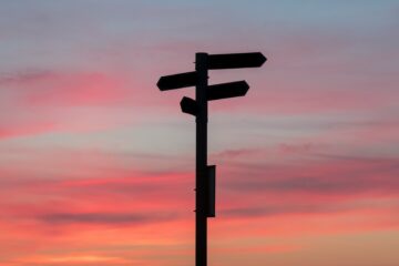 A rustic wooden signpost pointing toward a bright Colorado sky, representing a strategic transition in church financial leadership and bookkeeping methods.